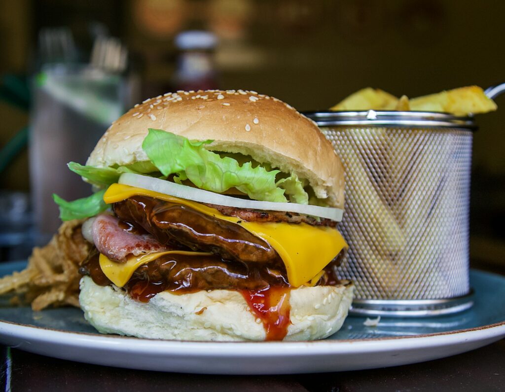 a plate with hamburger and a cup of chips