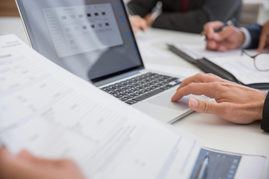 person using a laptop with a paper on left hand