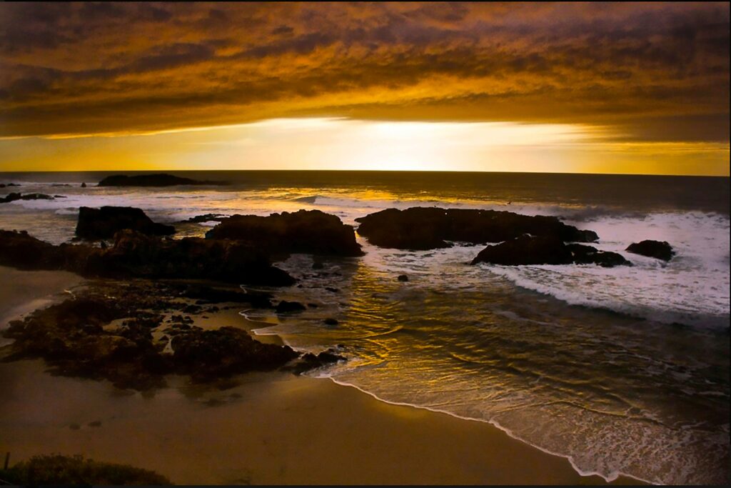 sunset over rocky beach with gentle waves