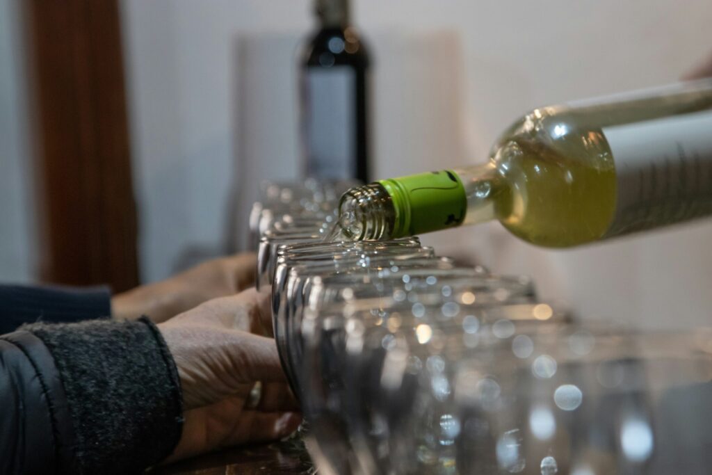 a person pouring wine into a glass