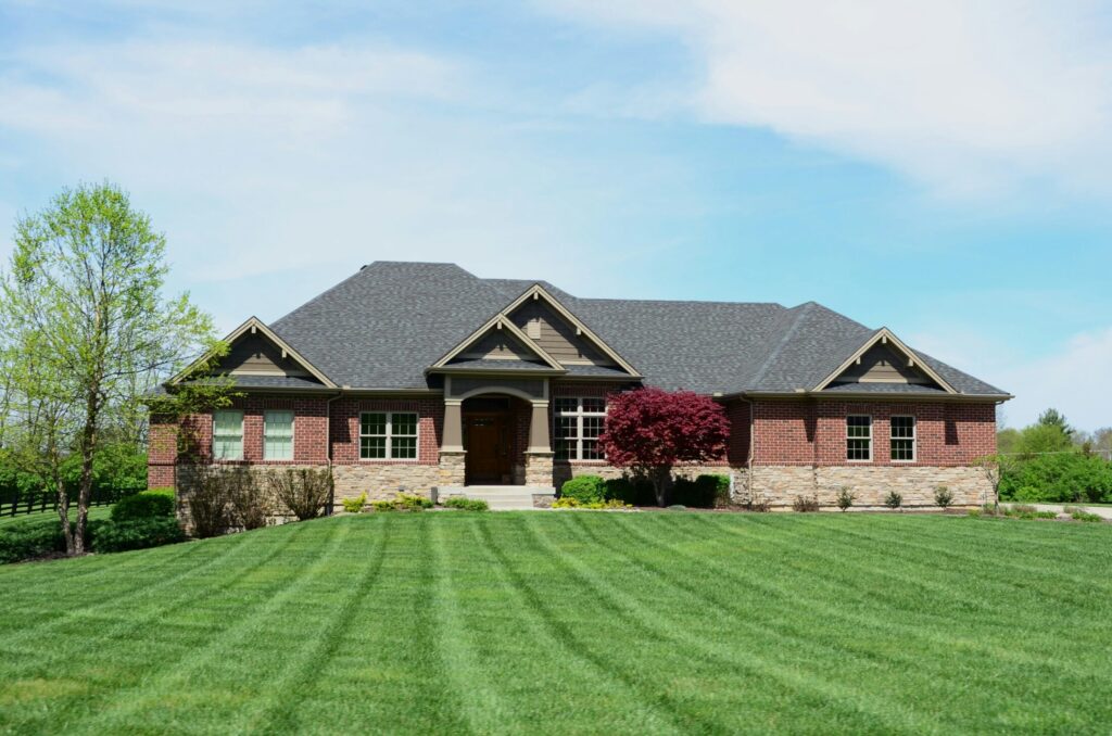 a brown brick house with a large lawn