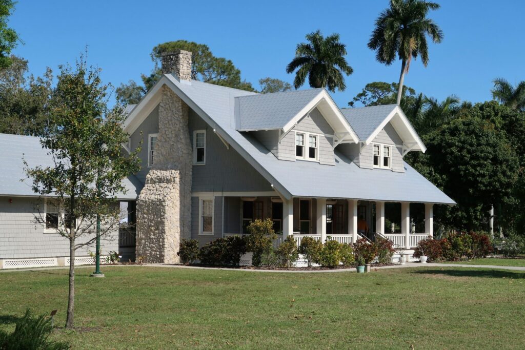brown and white concrete house near green grass field during daytime.