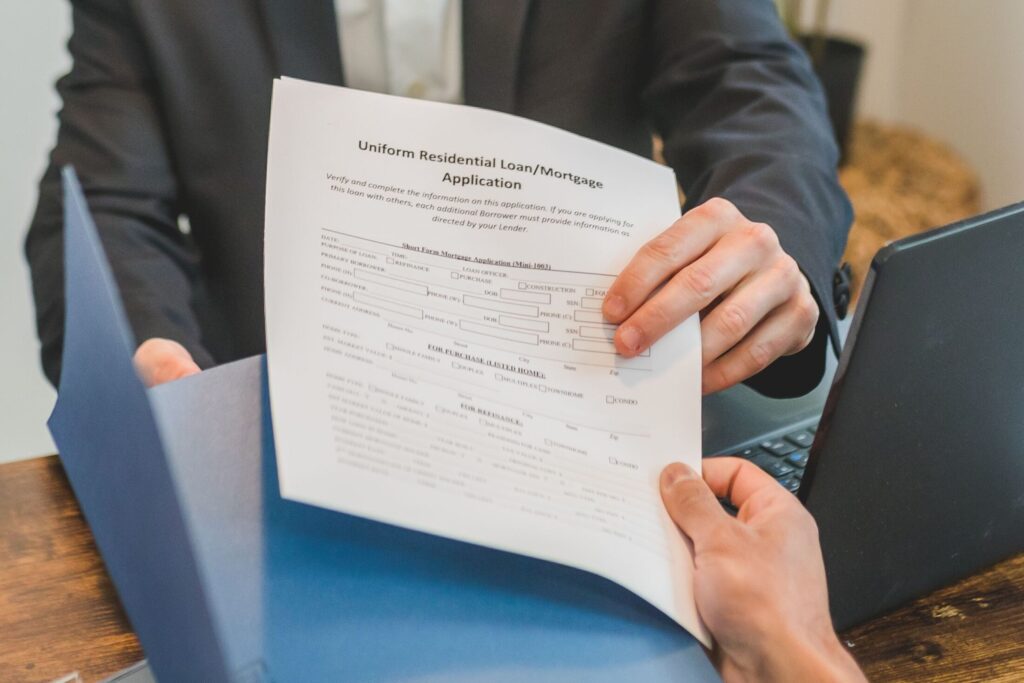 a person handing over a mortgage application form